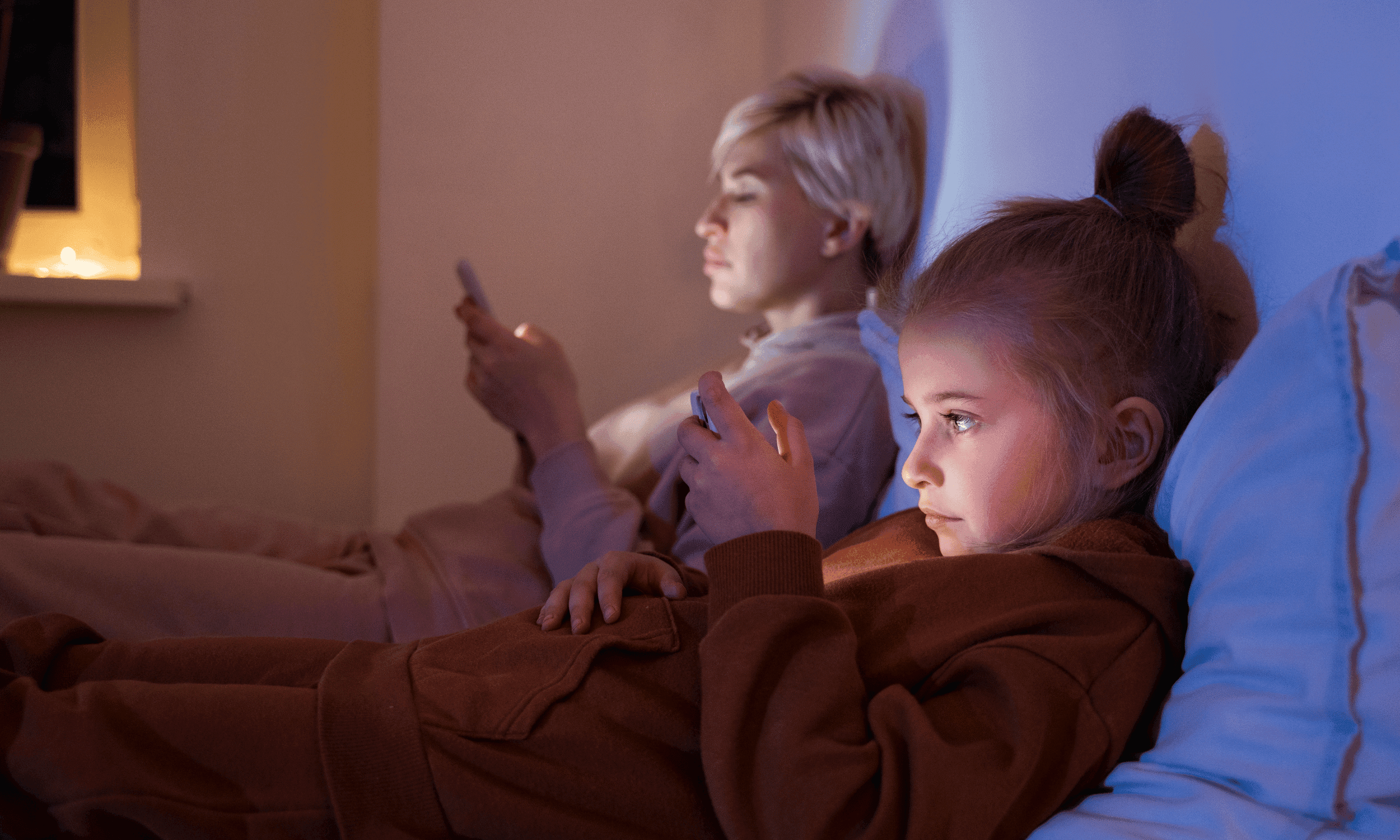 Two young viewers using handheld devices at home.
