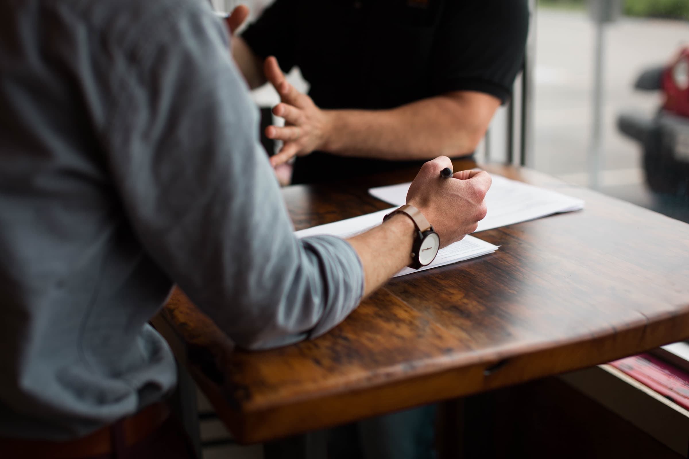 Two people discussing documents across a table